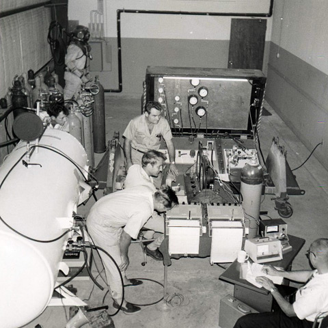 Shop at J & J Marine showing decompression chamber; Pete Edel in lower right corner, 